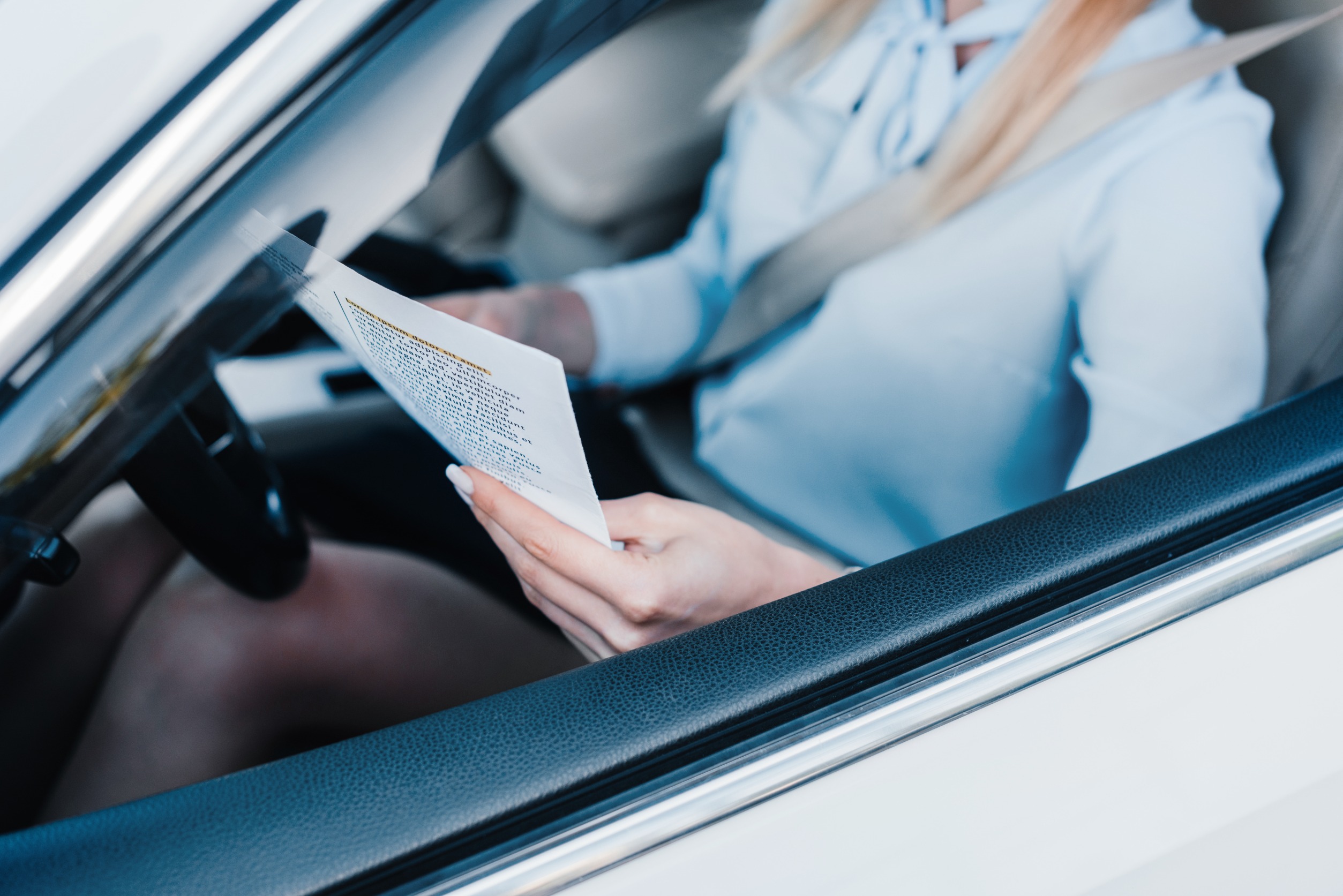 Chica en coches con papeles 