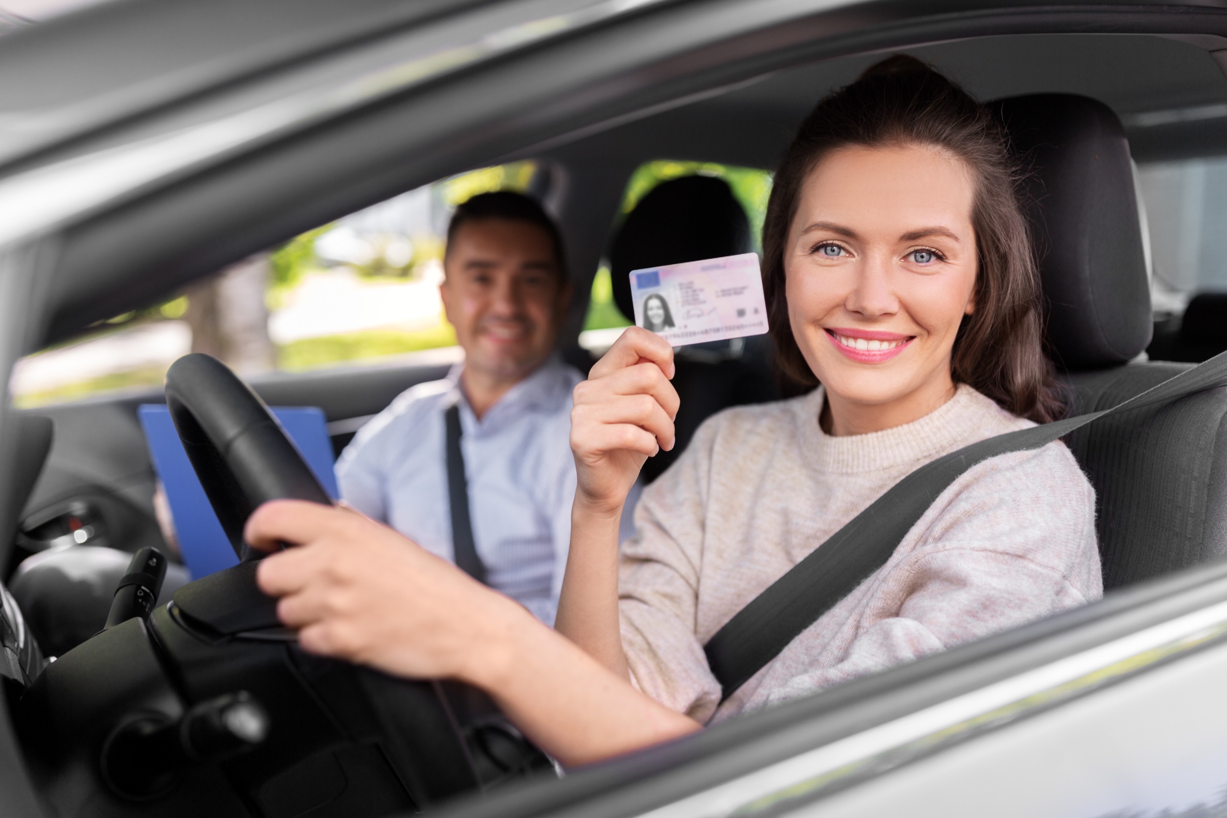 Chica en coche con carnet de conducir 